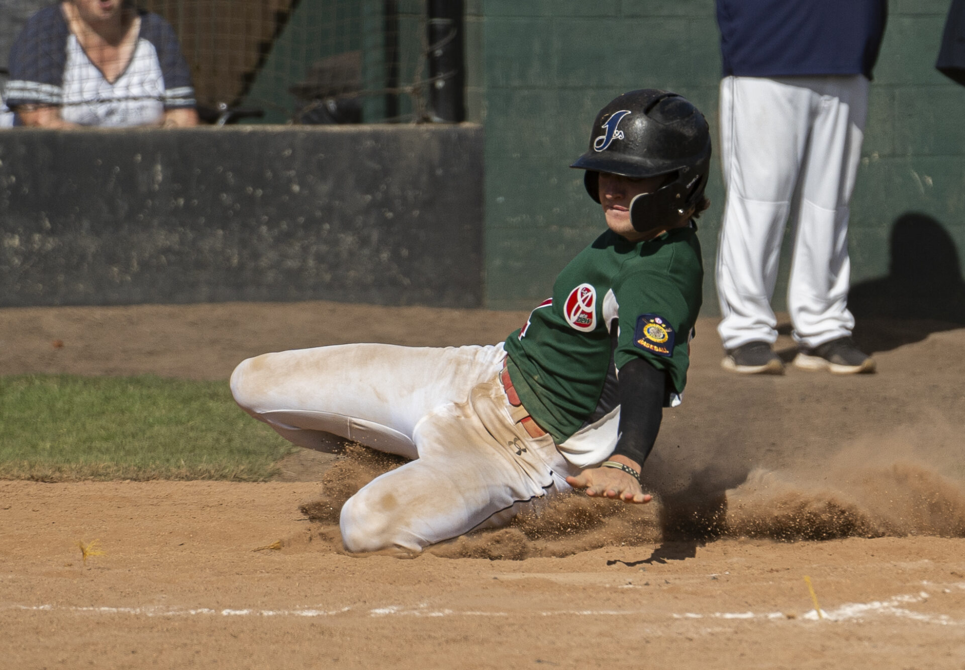 Baseball player slides into home plate.